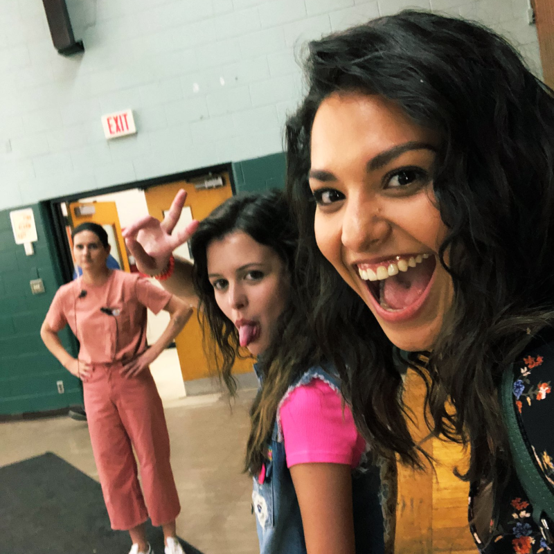 Two girls smile for a selfie on the set of a TV series