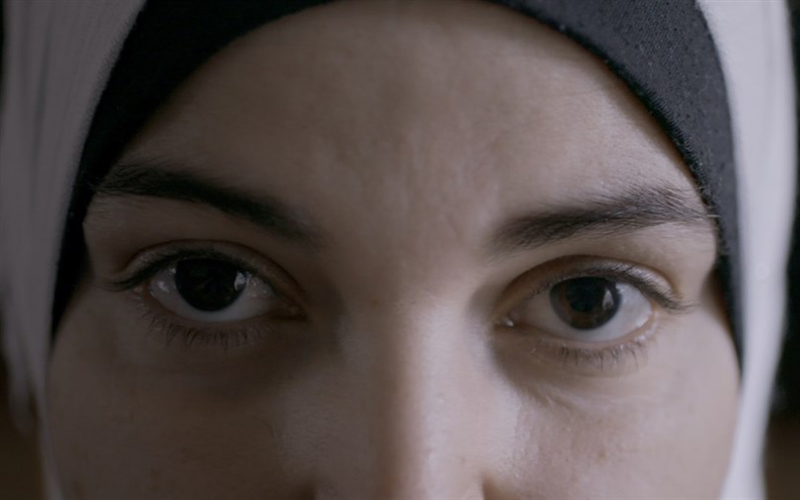 A close of a girls face, focusing on her eyes while she wears a religious head cover