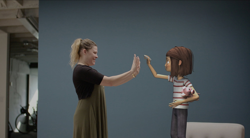 A woman holds up her hands and interacts with a "virtual being" 