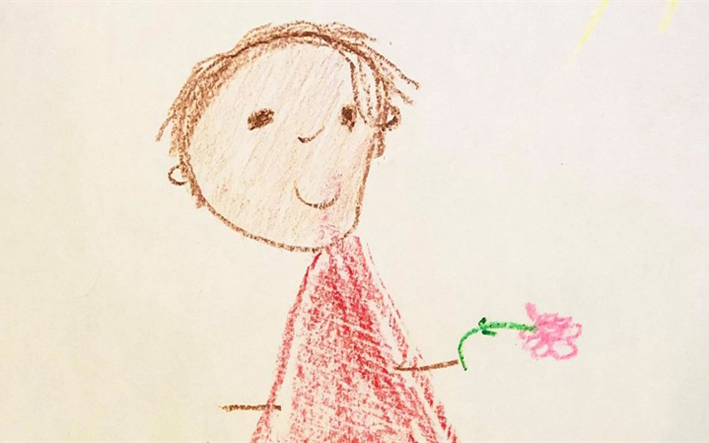 An image of artwork that was drawn by a young child which features a drawn boy holding a flower.