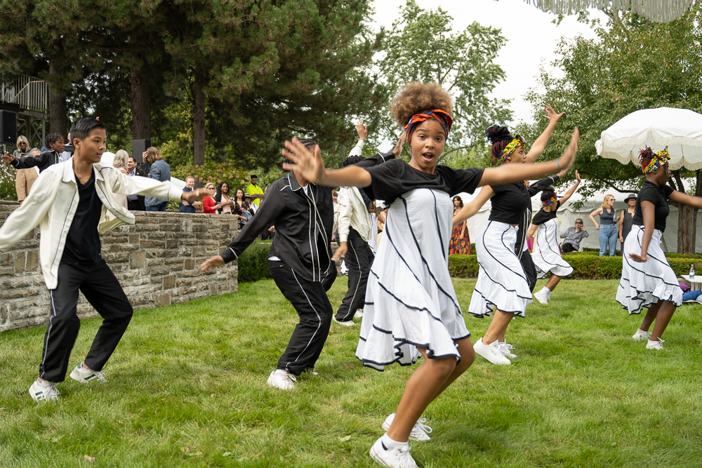 A group of hip hop dancers performing on the grass