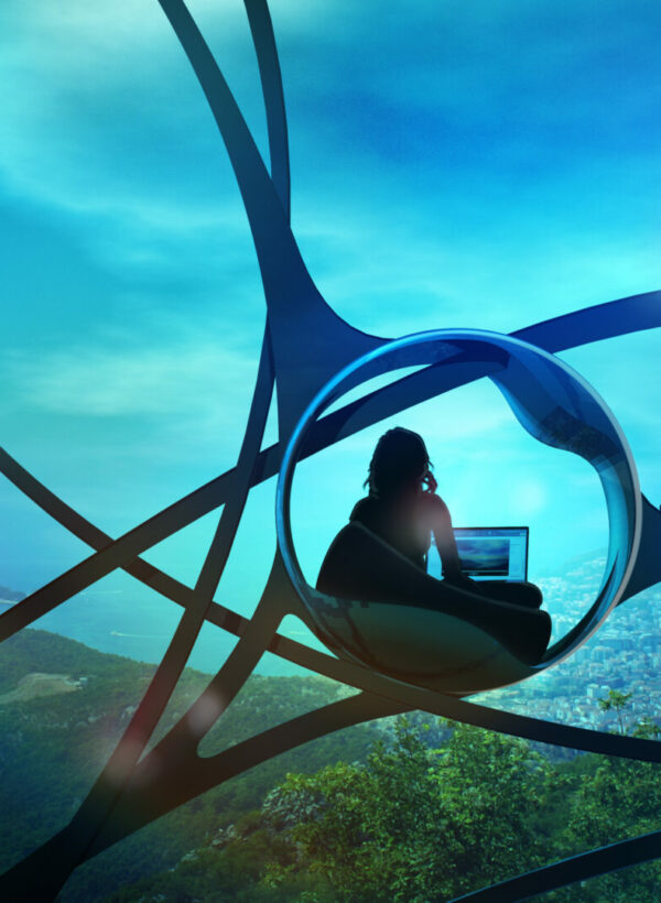 A woman sitting down in front of a computer working and building a beautiful world that engulfs her